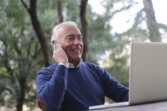 old man using phone and computer